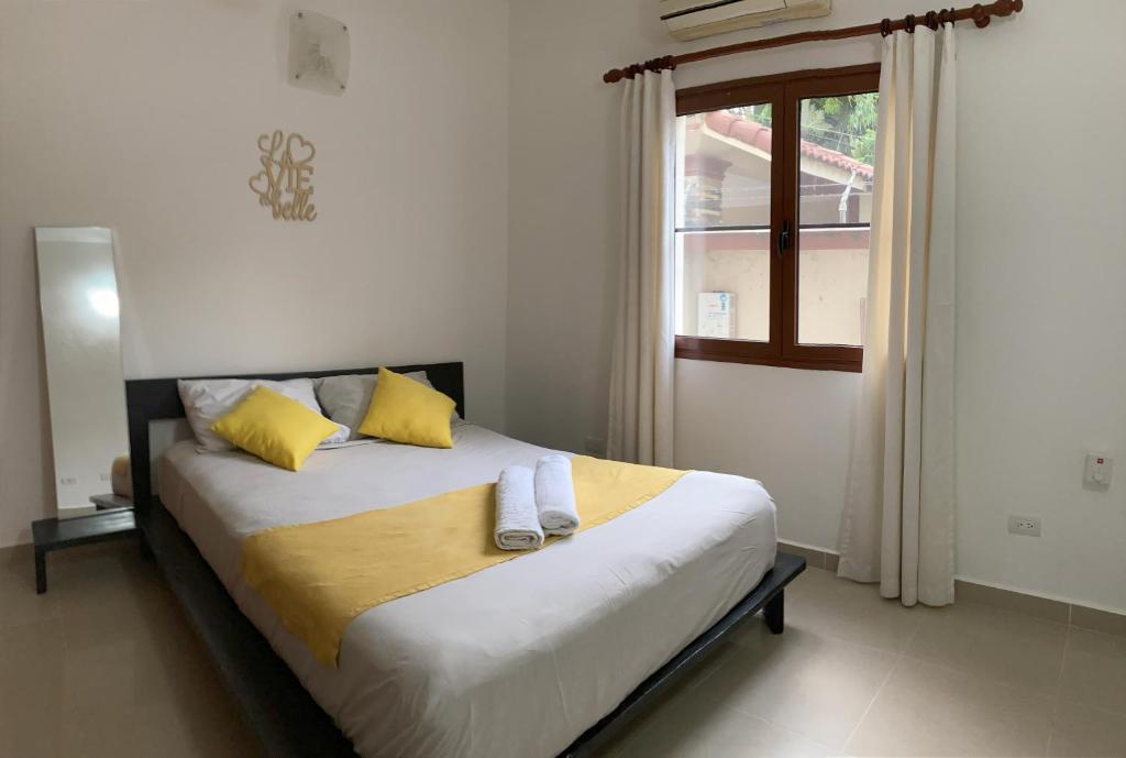 喀巴里特OKAINA 2的一间卧室配有一张带黄色枕头的床和一扇窗户