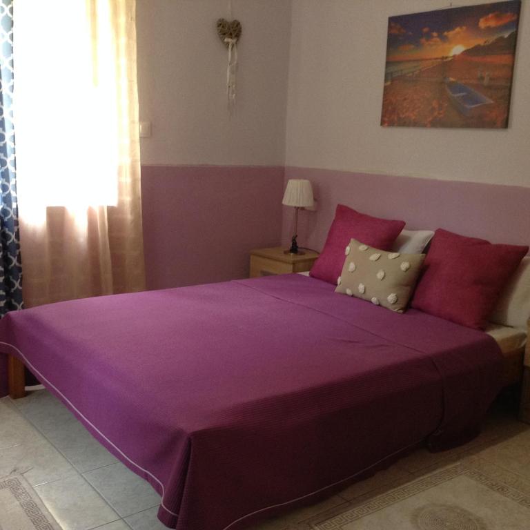 沃洛斯Η的带窗户的客房内的紫色床