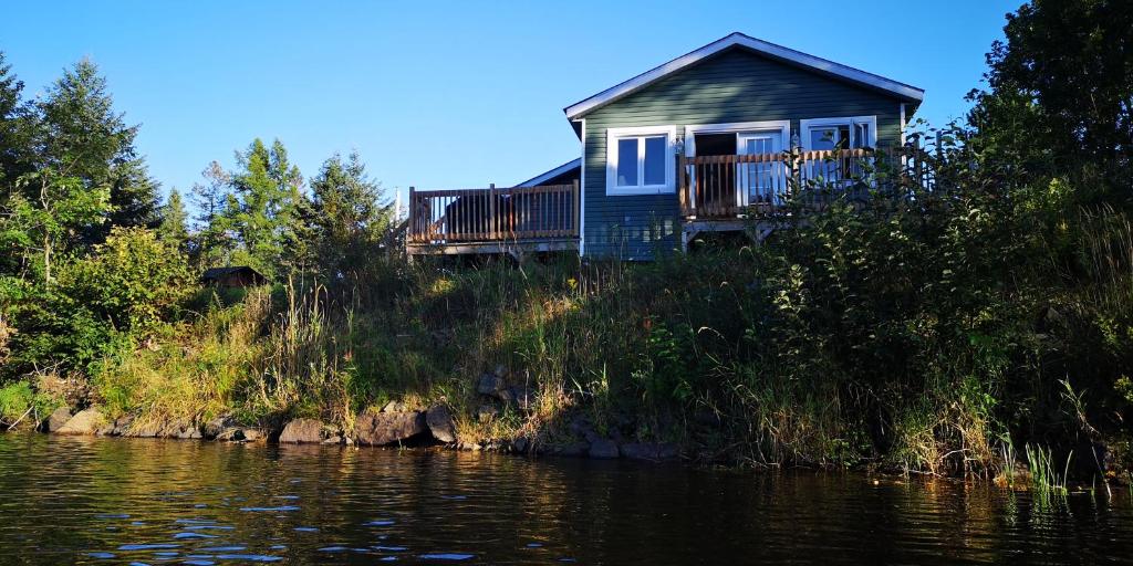Saint-PaulinLe Jasmin chalet complet Rivière Kayak Nature的河畔山丘上的房屋