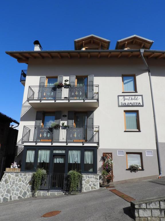 科姆梅扎杜拉Aparthotel Dolomites Living&Relax的一座大型白色建筑,设有阳台