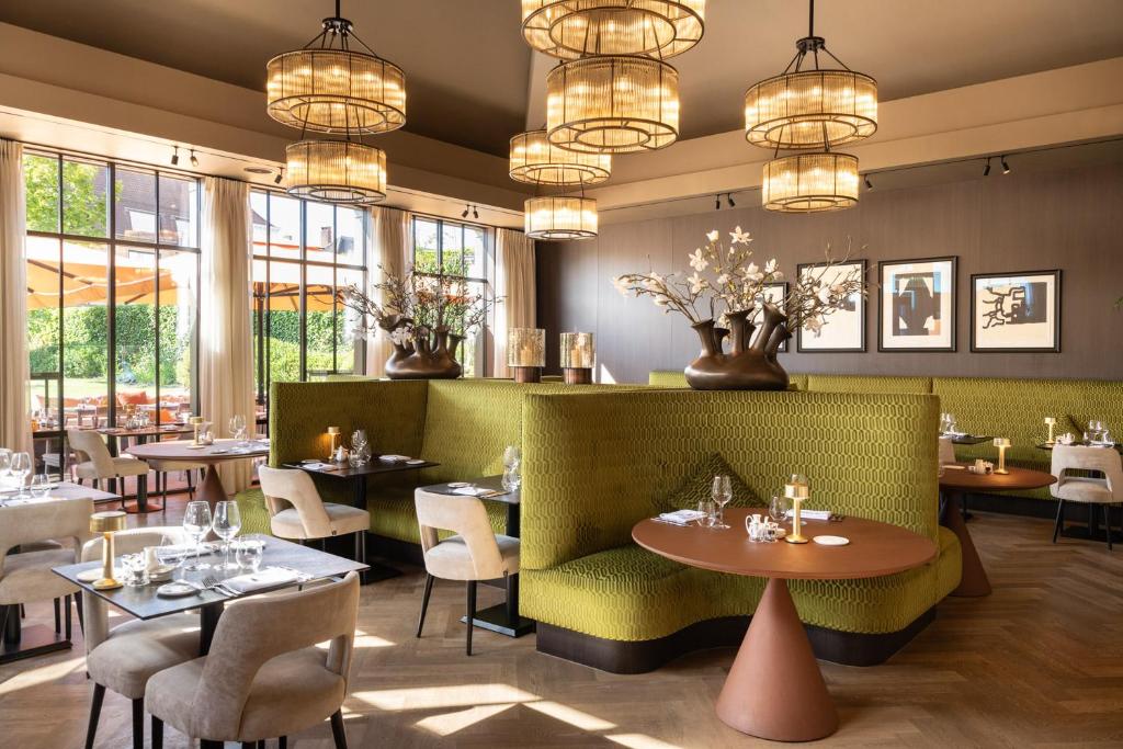 布鲁日Dukes' Palace Brugge的餐厅设有桌椅和吊灯。