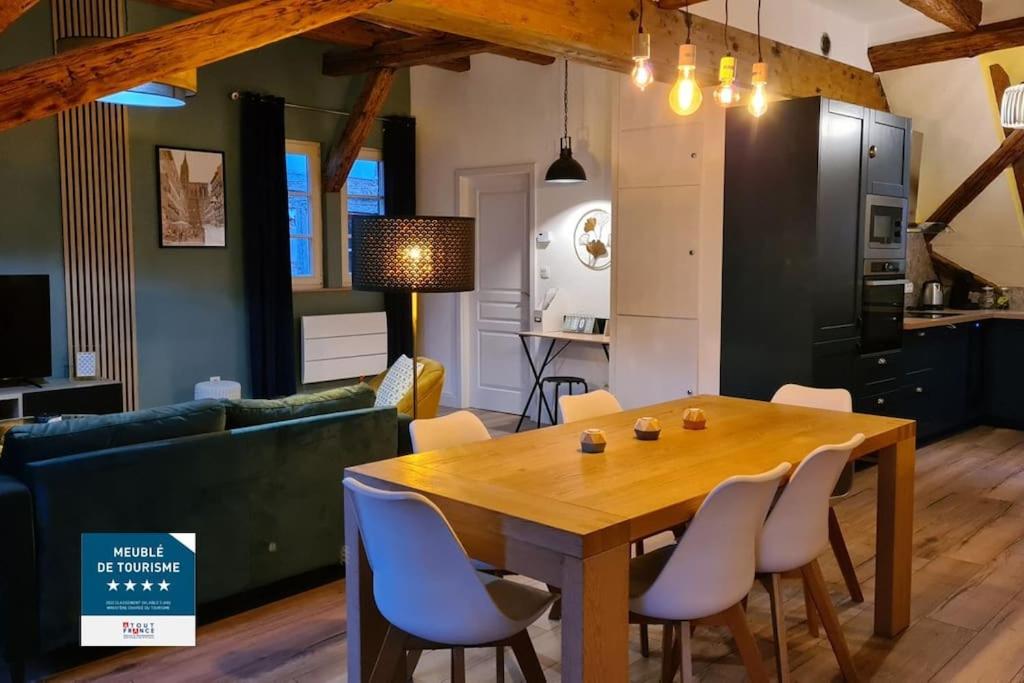 奥贝奈Duplex Centre - Le Marché的厨房以及带木桌和椅子的用餐室。