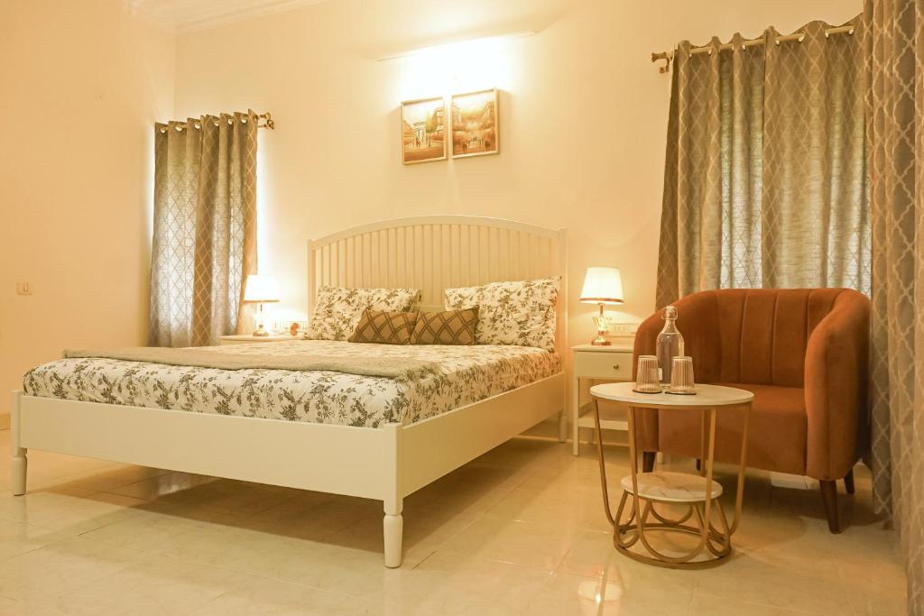 班加罗尔Luxre Homes - Villa in Koramangala的一间卧室配有一张床、一把椅子和一张桌子