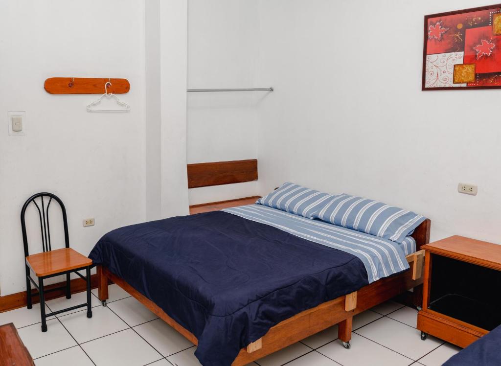 利马Yaki Hostel的一间卧室配有一张床和一把椅子