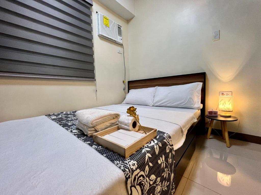 马尼拉Condotel Room to Stay Lodging的一间卧室设有两张床和一个带水槽的窗户。