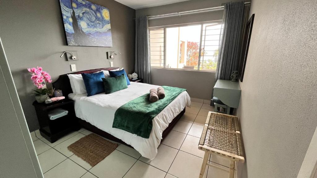 KingsboroughCassa De La Luna Diossa的一间卧室配有一张带蓝色枕头的床和一扇窗户。