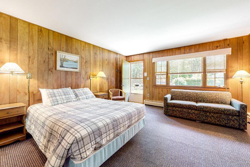 AltonKing Birch Lake Home, Unit 6的一间卧室配有一张床、一张沙发和一把椅子