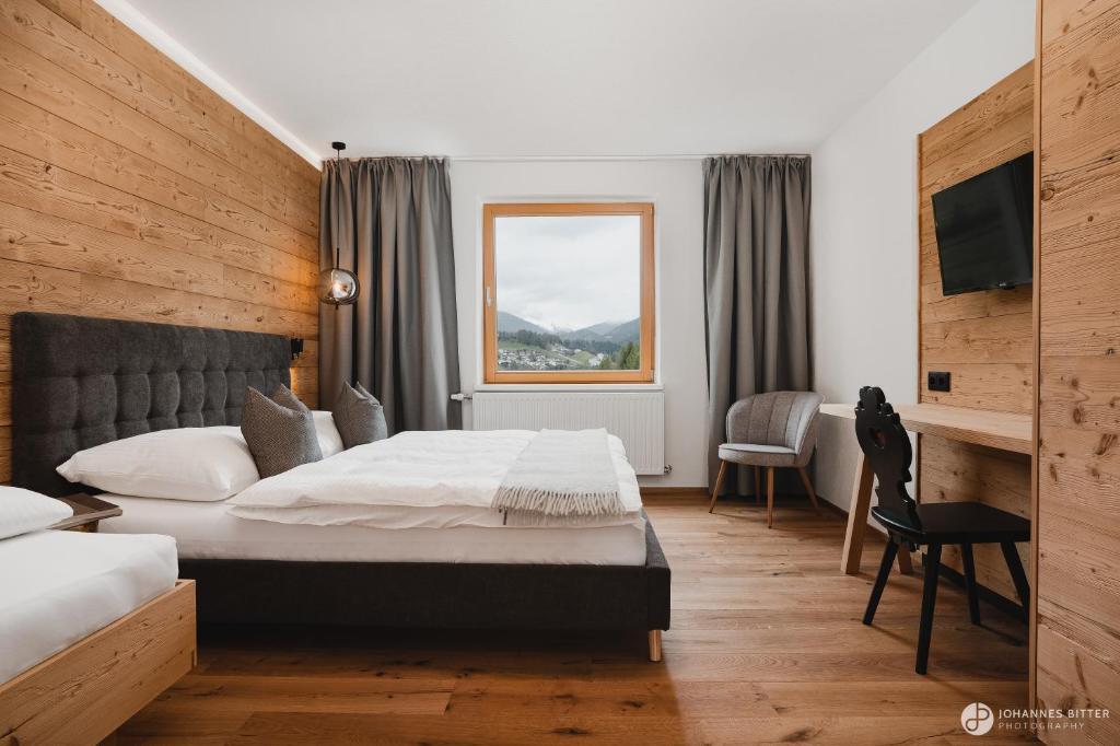 布伦纳山口附近马特赖Stoacherhof Apartments的配有一张床和一张书桌的酒店客房