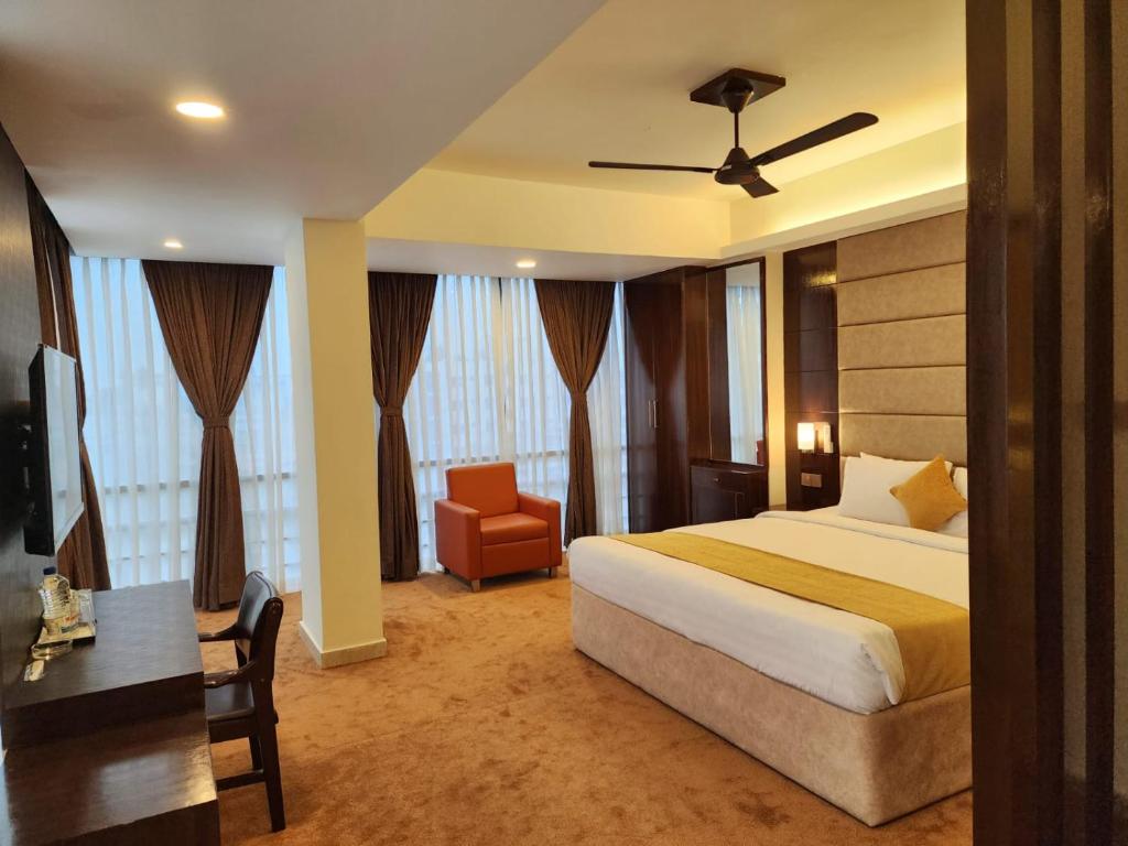 吉大港White Park Hotel & Suites的一间卧室配有一张床、一张桌子和一把椅子