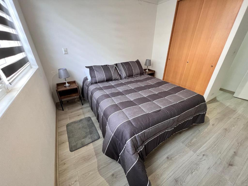 塔尔卡瓦诺Comoda Estadia en Talcahuano的一间卧室配有一张床和一扇木门