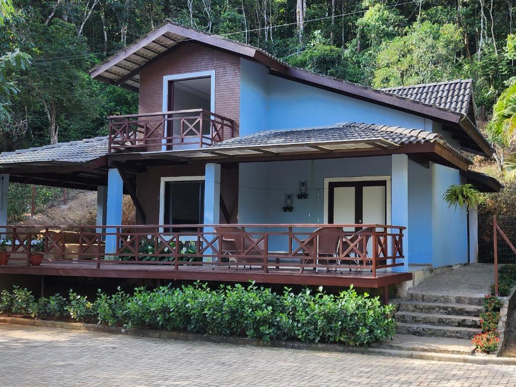 帕科蒂Casa do Luiz Antônio的蓝色的房子,上面设有门廊和椅子
