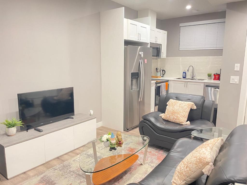 卡尔加里Cozy basement suite的客厅配有电视、沙发和椅子