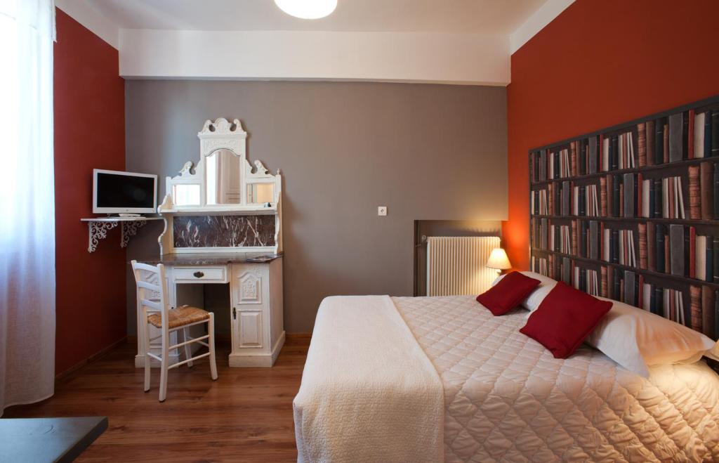 科利尤尔Hôtel la Bona Casa的一间卧室设有一张大床和一个书架