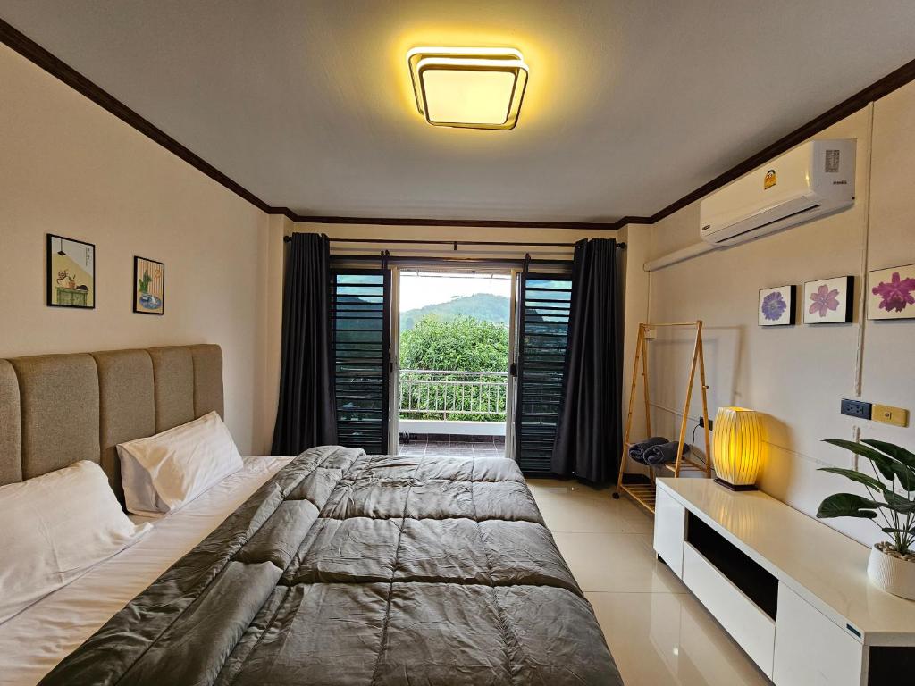Ban Komo Sip PaetAnda Betong Homestay的一间卧室设有一张大床和一个窗户。