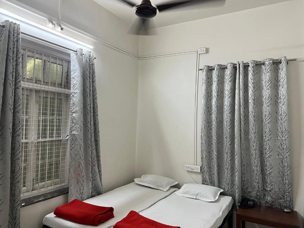 浦那Hotel Laxminarayan Niwas的一间卧室设有两张床和窗户。