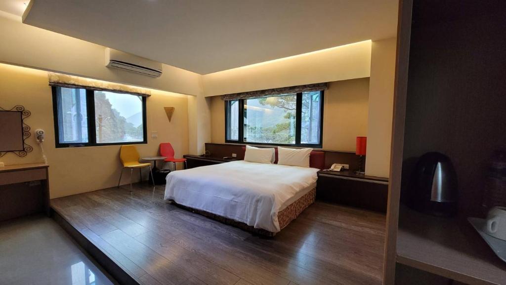 埔里香亭民宿的一间卧室设有一张大床和两个窗户。