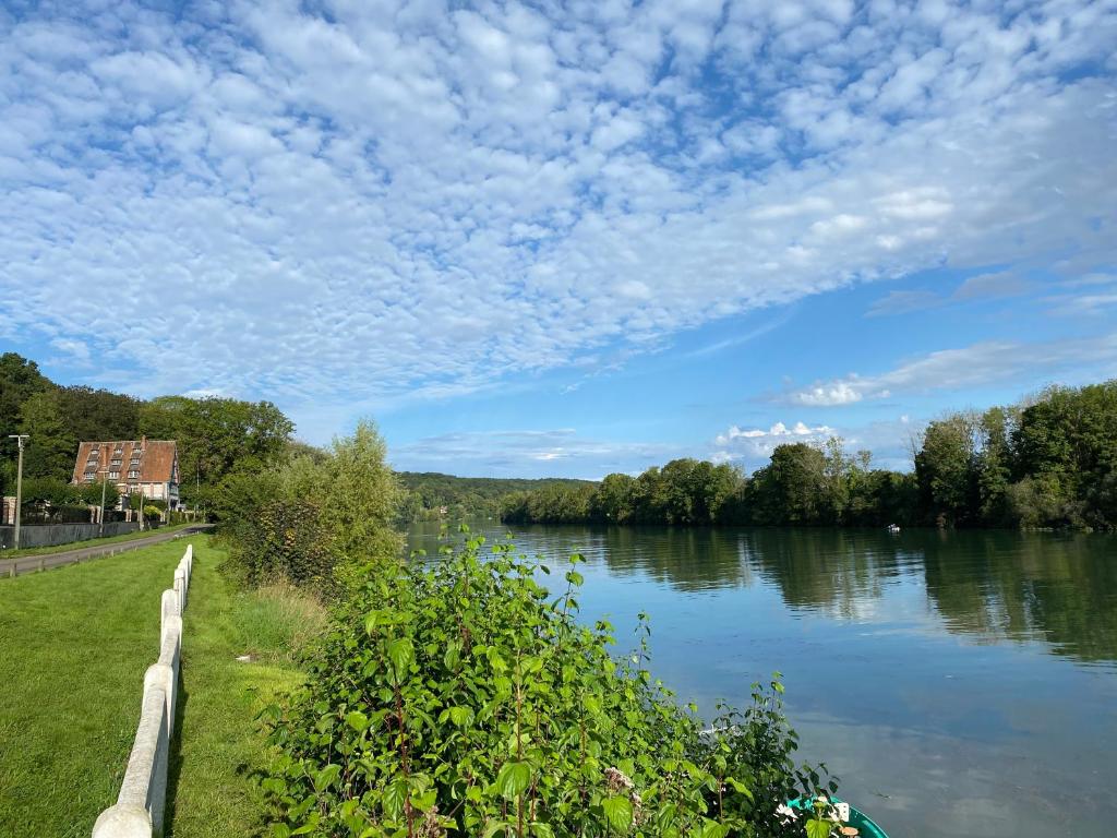 布瓦乐洛伊La Seine, entre rivière et forêt de Fontainebleau的享有多云的河流美景