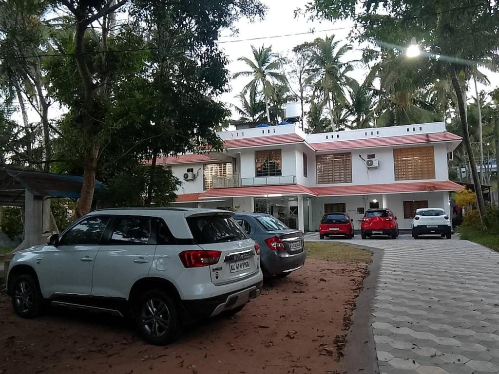 特里凡得琅Somatheertham Ayurvedic Resort的停在大楼前的一组汽车