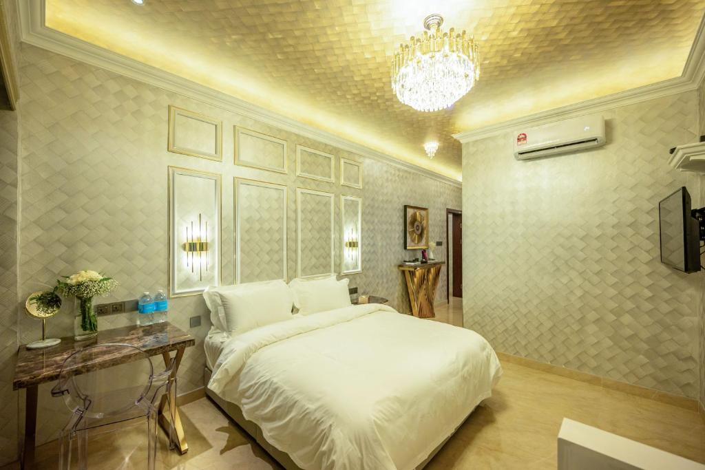 哥打京那巴鲁Ritz Residence @ Imago Loft B 7th Floor的卧室配有一张白色大床和吊灯。