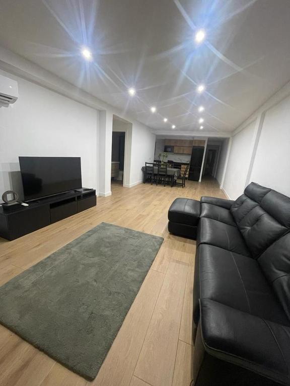 萨贡托UIM Mediterraneo Conqueridor Wifi的客厅配有黑色沙发和平面电视。