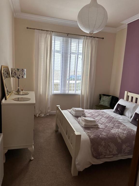 斯特灵Castle Brae Apartment的一间卧室配有一张床、一张书桌和一个窗户。