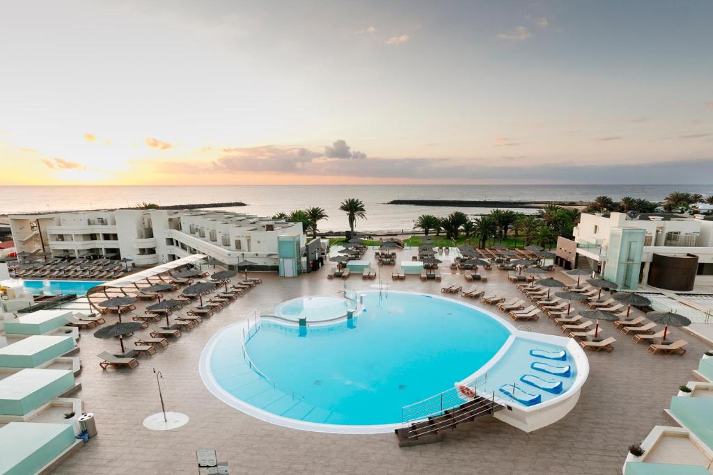 科斯塔特吉塞HD海滩度假酒店的享有带游泳池和椅子的度假村的空中景致