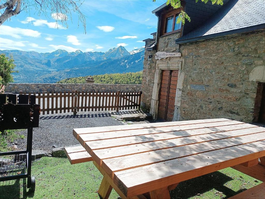 圣拉里苏朗La grange du hameau的坐在大楼外的木餐桌