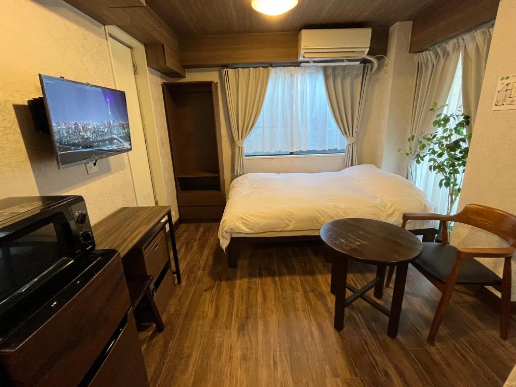 东京Cozy inn Oyama的小房间设有床、桌子和电视