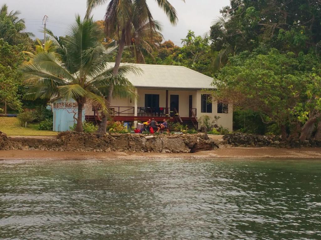 卢甘维尔Santo Seaside Villas的水体岸边的房子