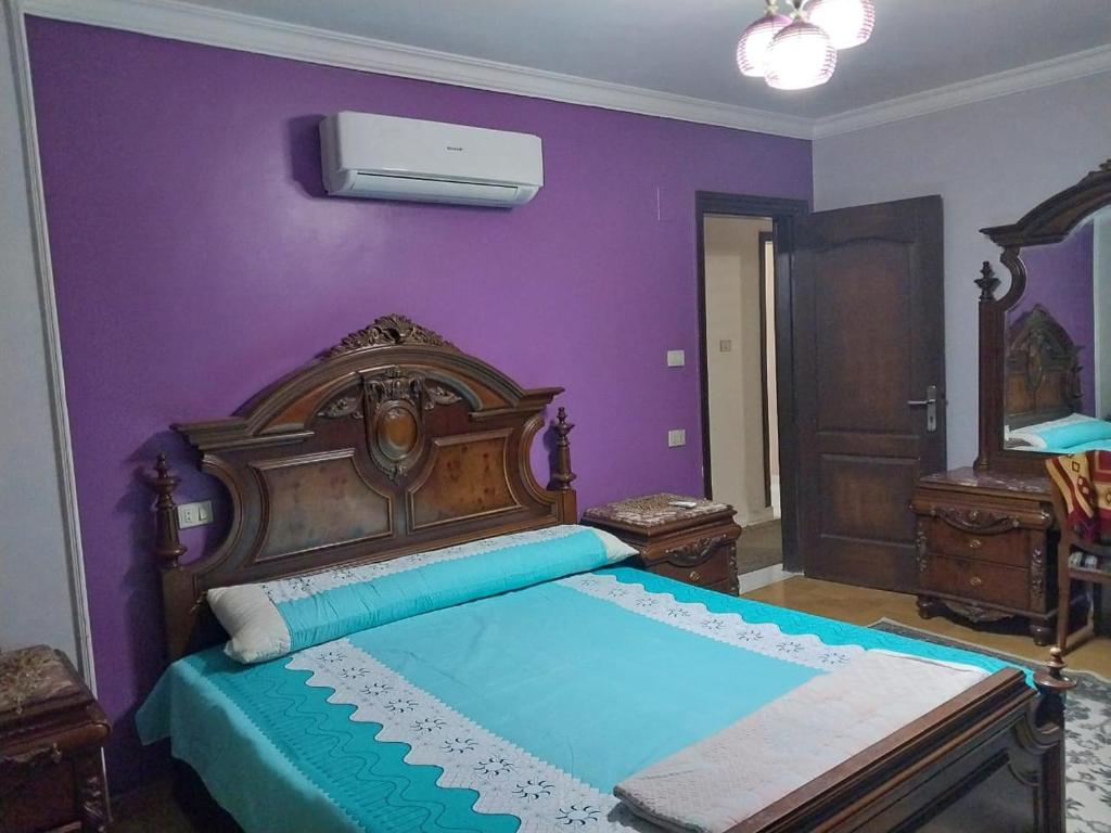 开罗Compound city towers的一间卧室配有一张大床和紫色墙壁