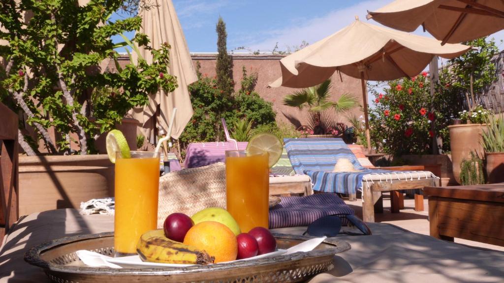 马拉喀什阿尔卡萨Spa庭院旅馆的桌上一篮水果和两杯果汁