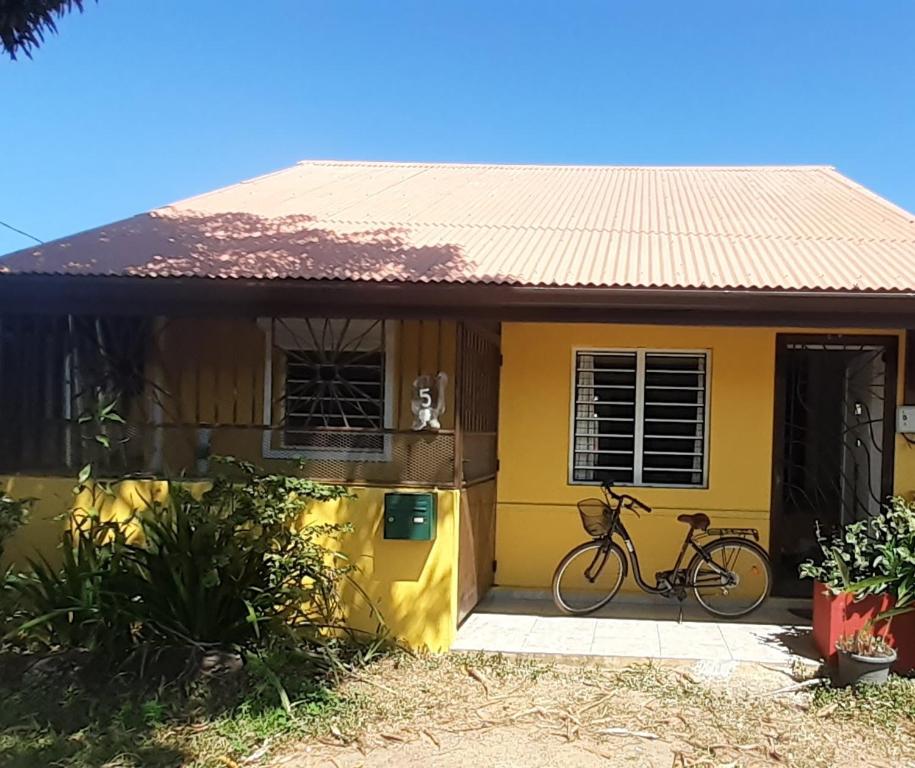 卡宴Le Patio Fleuri - Studio et terrasse privé à Cayenne的停在黄色房子前面的自行车