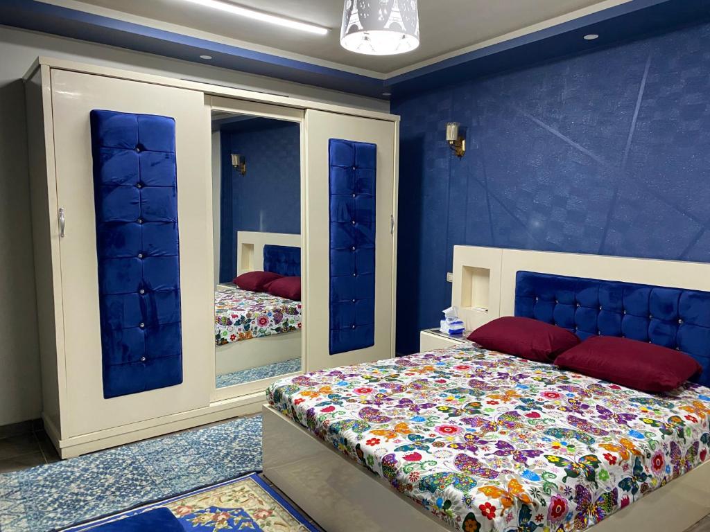 艾斯尤特Assuit ultra modern apartment的一间卧室设有蓝色的墙壁、一张床和镜子