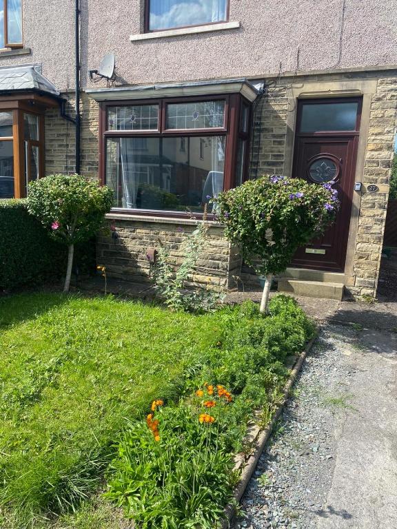 哈德斯菲尔德Huddersfield 2 bedroom house的前面有鲜花的院子的房子