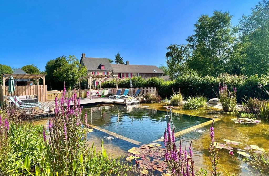 La Chapelle-EngerboldGreener Pastures - Normandy Self Catering Gites的一座花朵紫色的房子前的池塘