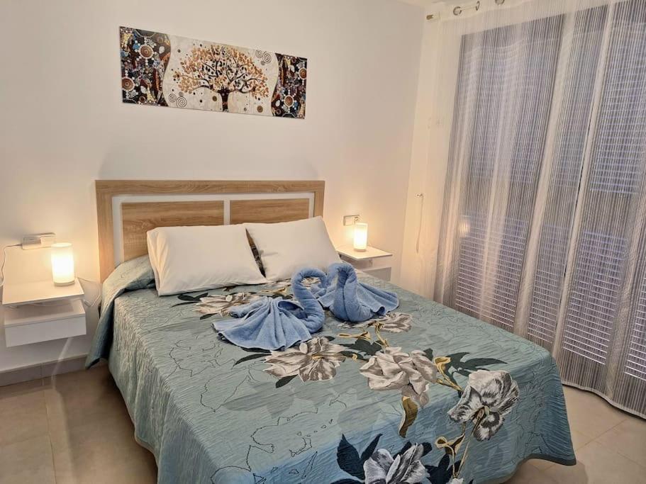 莫哈卡尔Sea view cozy apartment La Tanita的一间卧室配有一张带蓝色毯子的床