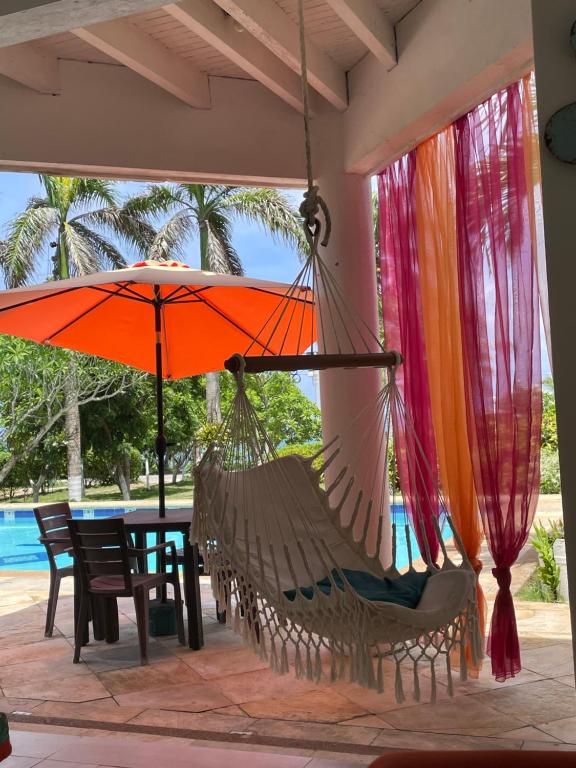 圣安德烈斯Casa de las Flores tropical的天井上的吊床,配有桌子和遮阳伞