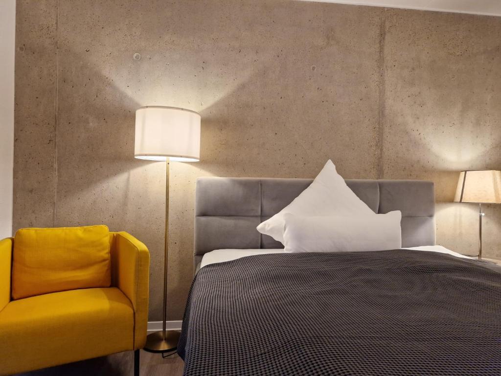 比勒费尔德Urban City Lifestyle Appartement的一间卧室配有一张床和一张黄色椅子