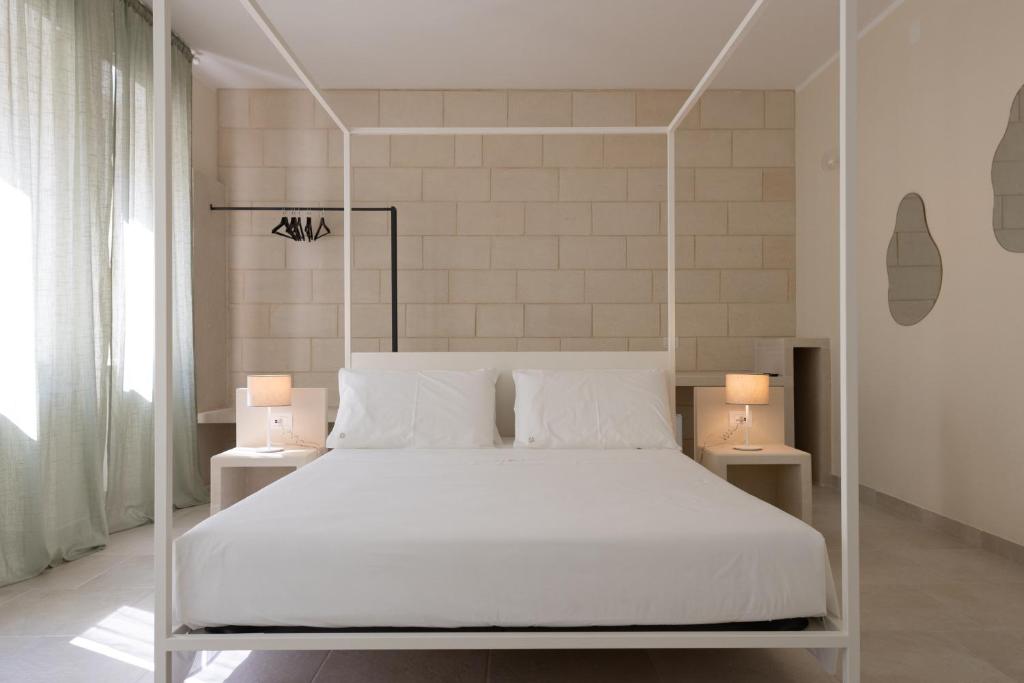 莱切Oronti Accommodations的卧室配有带两盏灯的白色床
