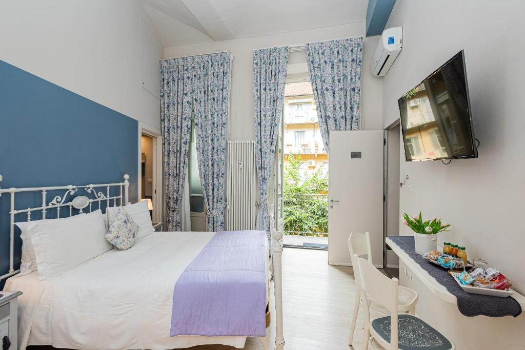 都灵Maison Rêve Torino Centro的一间卧室设有一张床、一台电视和一个窗口。