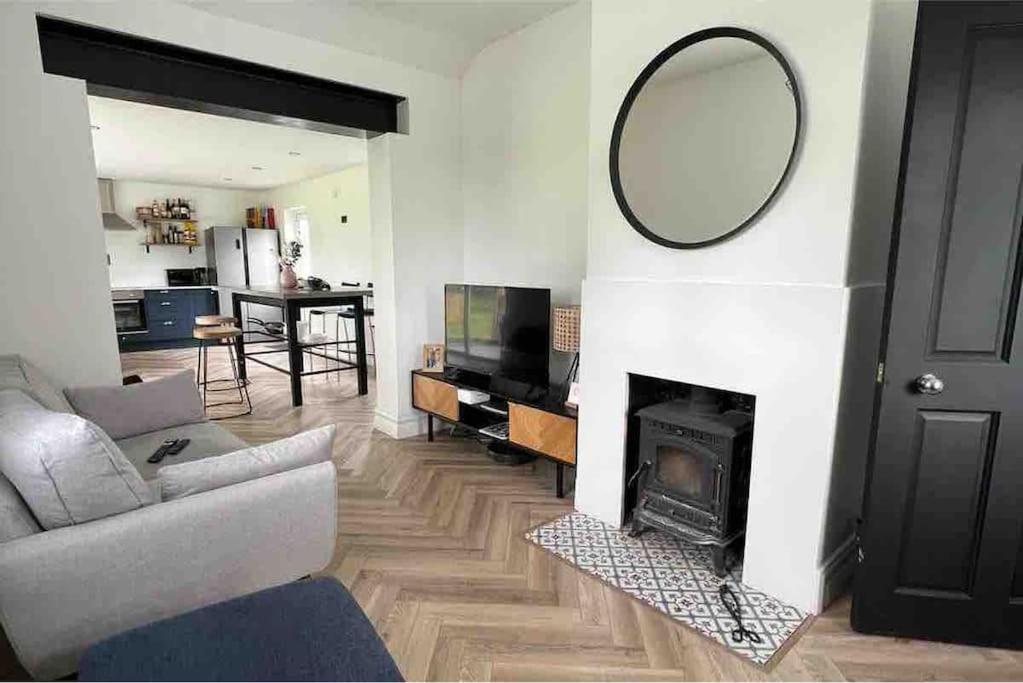 基尔肯尼Ballybur Cottage的客厅设有镜子和壁炉