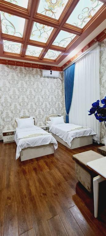 Andizhansheykh hotel的带三张床和天花板的客房