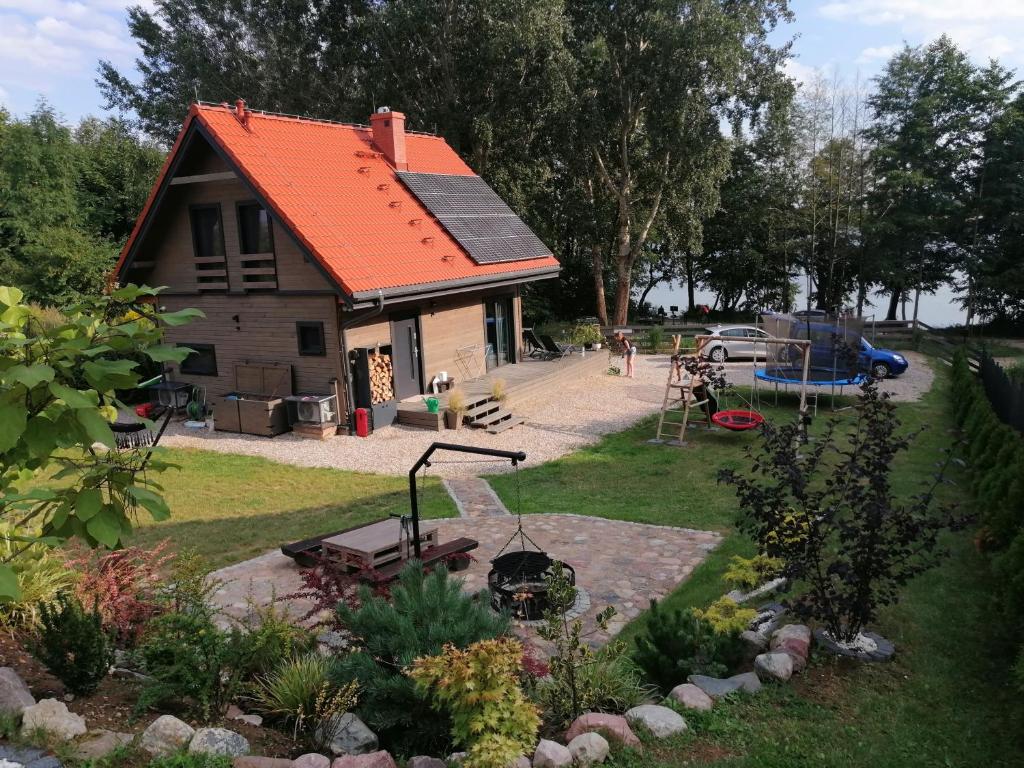 文戈热沃Mazurska Widokówka的一座带橙色屋顶和后院的小房子