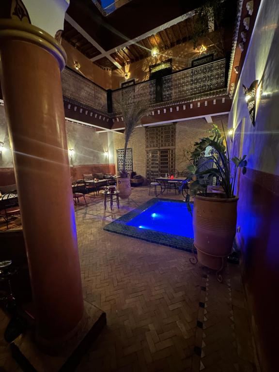 马拉喀什娜雅庭院旅馆的一座游泳池,位于一间有建筑的房间中间