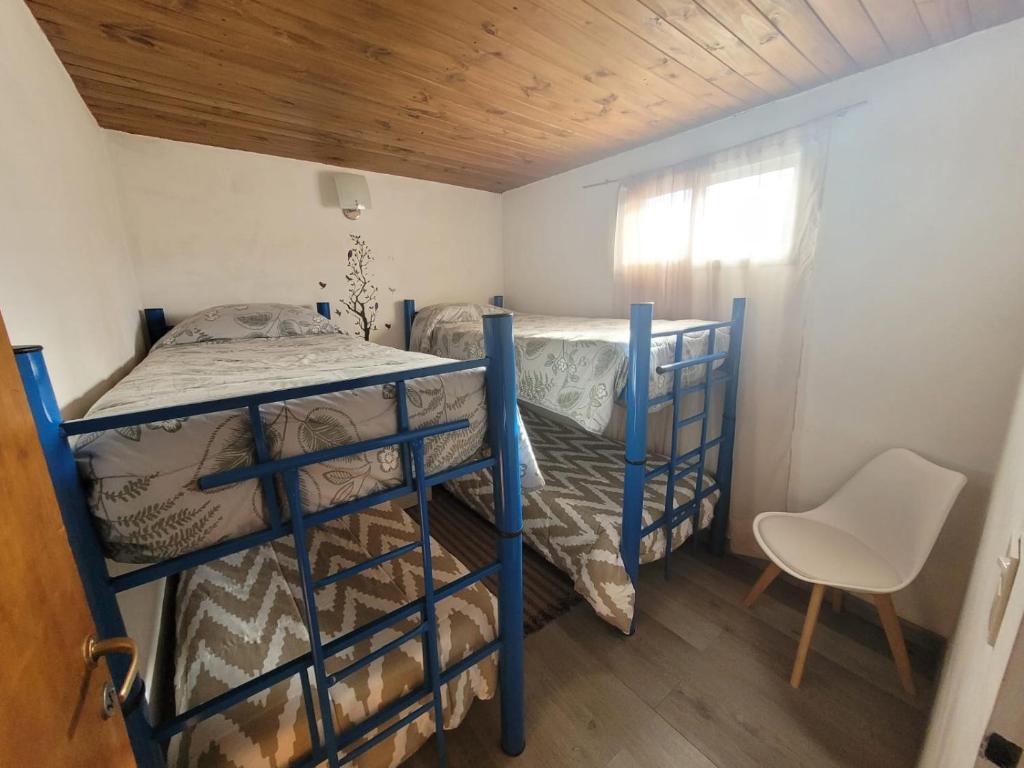 圣卡洛斯-德巴里洛切RyG Apartments的一间卧室配有两张双层床和椅子