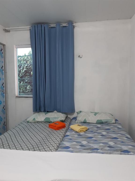 纳塔尔Pousada do Joaquimxdarc的一张带两个枕头和蓝色窗帘的床