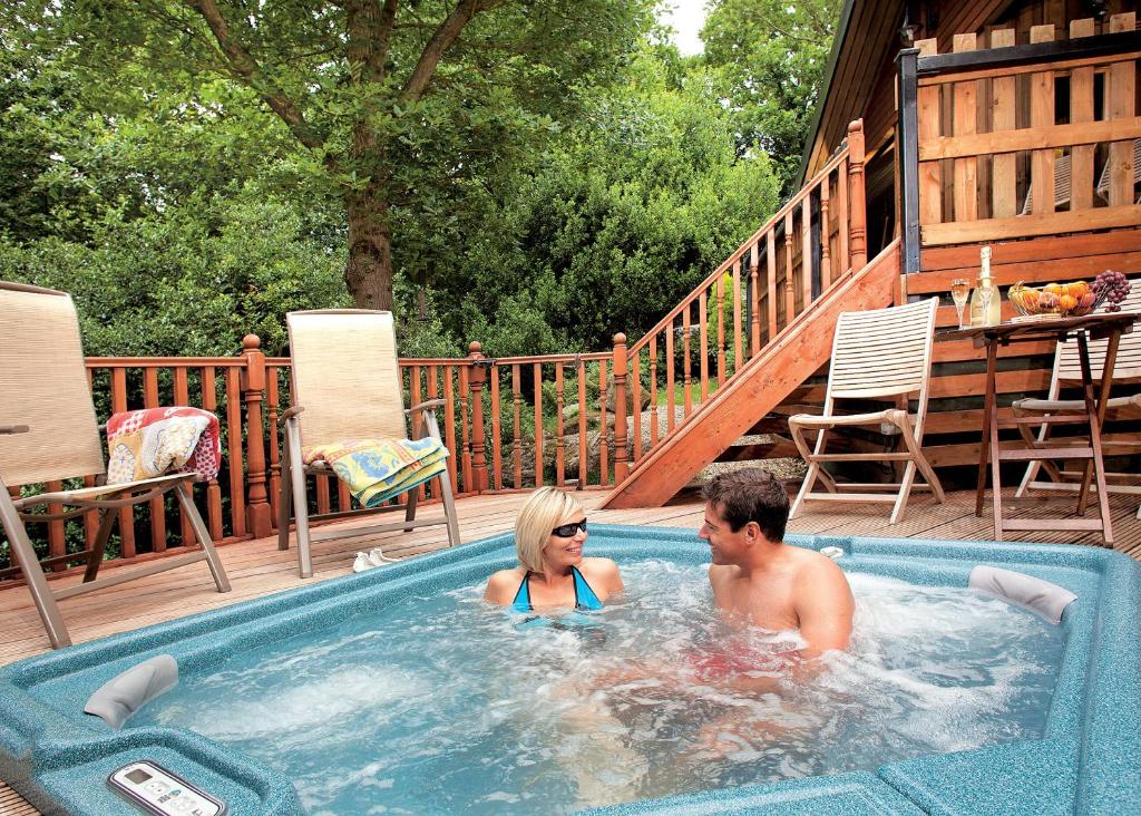 哈罗盖特Springwood Lodges的游泳池里按摩浴缸里的男人和女人