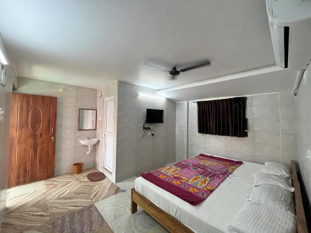 蓬蒂切里Royal Grand Residency的一间卧室配有一张床和一台电视。