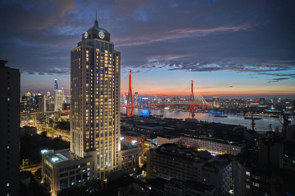 上海上海浦东滨江喜来登酒店的一座高大的建筑,上面有钟