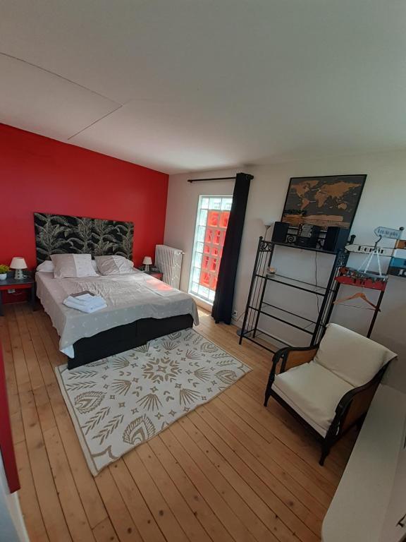 塞纳河畔埃皮奈Chambre d'hôte près de Paris的一间卧室配有一张大床和一把椅子